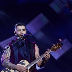 O cantor Gusttavo Lima trocou de roupa e voltou ao palco em look roxo