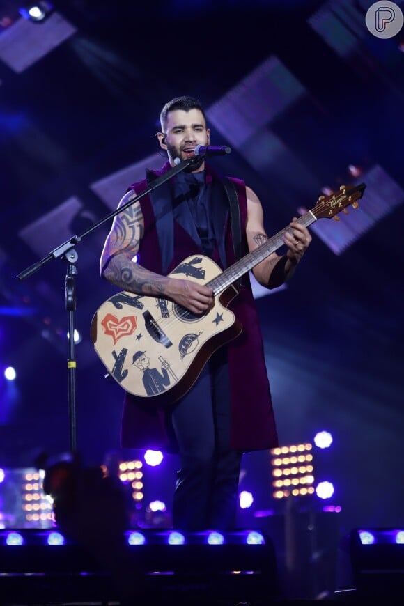 O cantor Gusttavo Lima trocou de roupa e voltou ao palco em look roxo