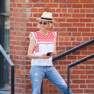 Calça jeans reta foi aposta de Naomi Watts nesse look fofíssimo, combinada ao top em estilo boho, chapéu panamá e tênis