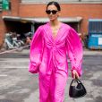 Vestido com mangas amplas em rosa neon e bolsa de mão em um look ultrafeminino para o verão 2020