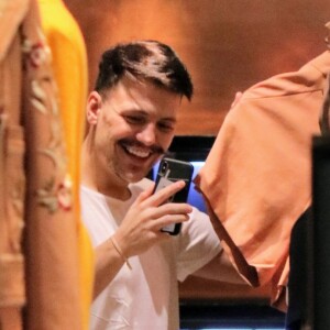 Cantor Saulo Poncio se diverte no telefone em ida às compras
