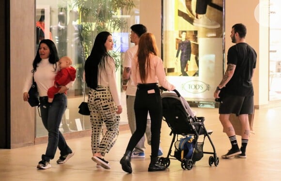 Mãe de Saulo, Simone Poncio carrega o neto João Márcio no colo em passeio no shopping