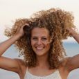Para quem tem cabelo cacheado, investir num finalizador com protetor solar ajudar a proteger os fios tingidos no verão