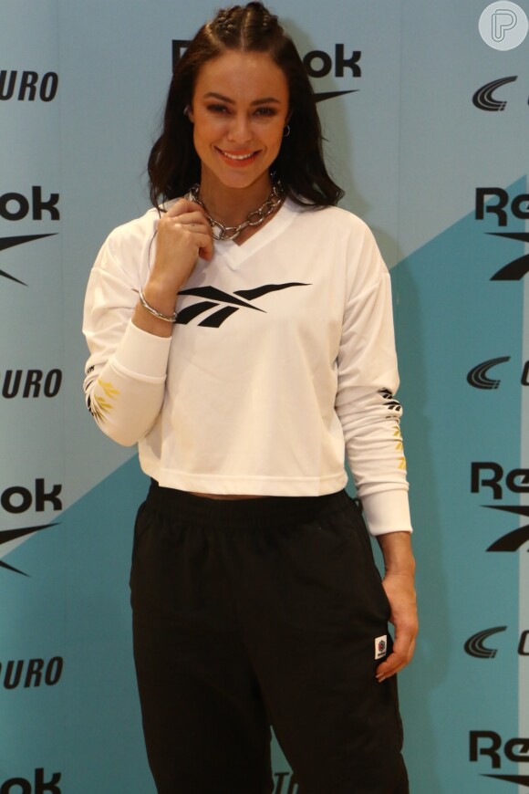Paolla Oliveira combinou blusa branca, calça de moletom e tênis da Reebok