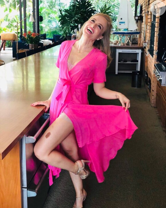 Angélica é fã do rosa neon e aposta no vestido midi de modelo envelope