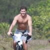 Klebber Toledo anda de bicicleta na orla da praia da Reserva, na Zona Oeste do Rio de Janeiro