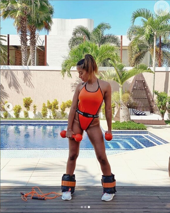 Anitta usou maiô laranja asa-delta para malhar