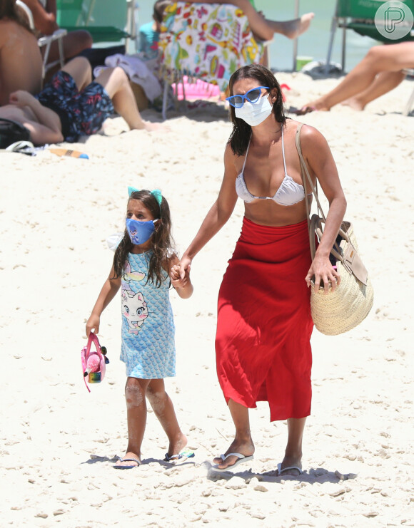 Deborah Secco e a filha, Maria Flor, não dispensaram a máscara de proteção ao deixarem praia do Rio