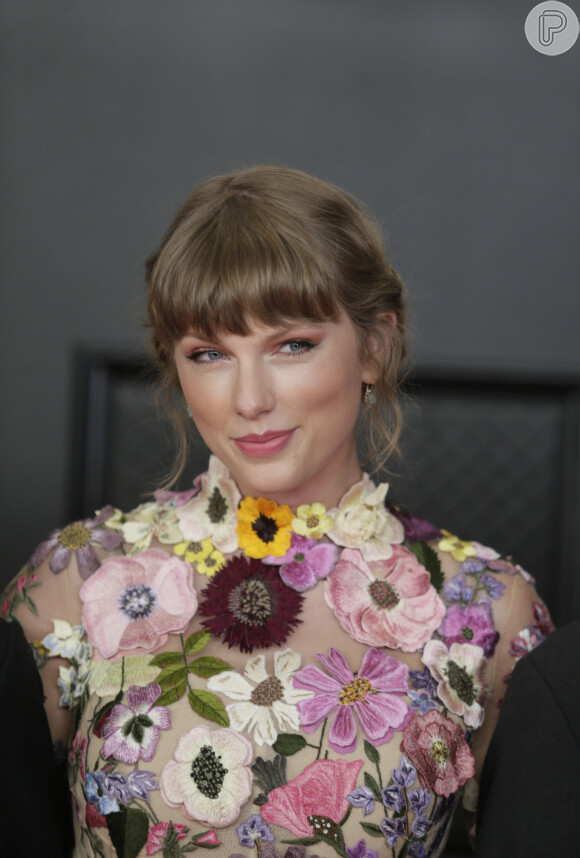Taylow Swift aposto em penteado preso com fios desconectados e franjinha reta acima das sobrancelhas para o Grammy 2021