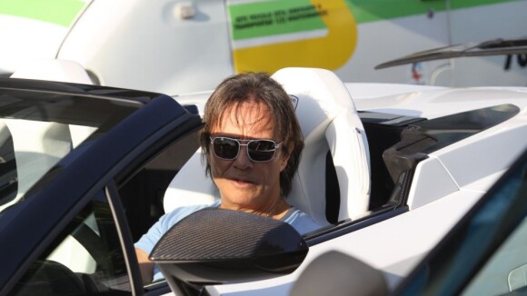 Roberto Carlos, com seguranças, dirige carro importado pelo Leblon para gravação
