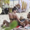 Thaila Ayala e Paulinho Vilhena pegam sol na Prainha, na Barra, no RJ
