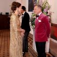 Kate Middleton, com vestido dourado, conversa com Daniel Craig em estreia