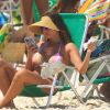 Deborah Secco mexe no celular na Praia da Barra da Tijuca, Zona Oeste do Rio