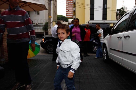 Rodrigo, de 4 anos, filho de Fausto Silva, chega na festa e dá um sorriso tímido