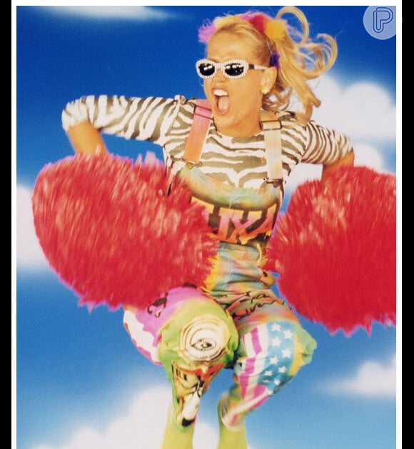 Xuxa pula usando um arco colorido na cabeça, deixando as mechas loiras esvoaçantes