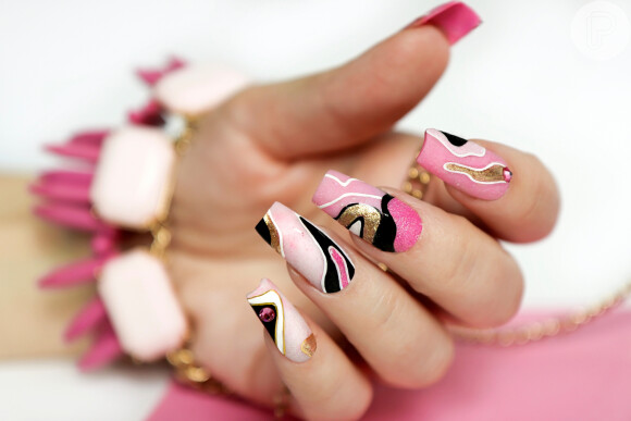 Esmalte rosa, preto, branco e dourado se combinam nessa nail art extravagante