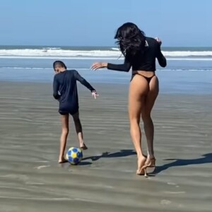 Pabllo Vittar brinca com criança na praia mesmo de salto alto.