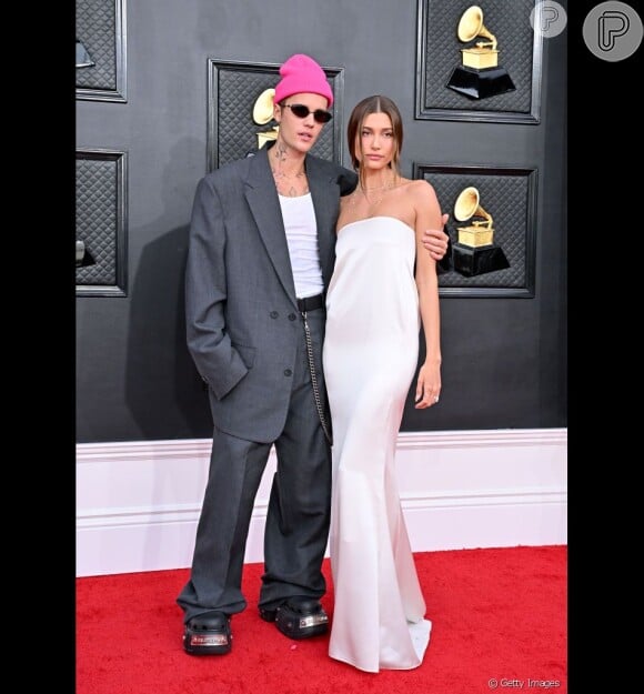 Justin Bieber aposta em look composto por conjunto de moletom monocromático cinza, crocs amarela e boné rosa para sair com Hailey