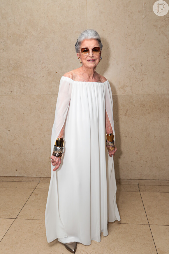 O vestido branco usado por Constanza Pascolato tinha modelagem fluida e decote ombro a ombro