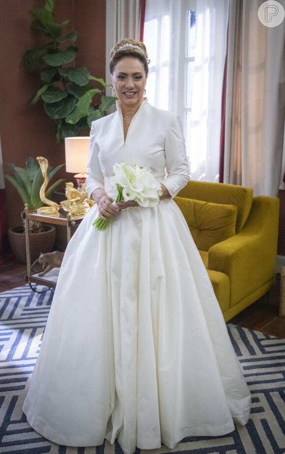 Em Terra e Paixão, vestido de noiva de gola alta de Agatha (Eliane Giardini) tem tecido levemente acetinado e sem rendas, o look é mais tradicional e sem muito romantismo, combinando com o perfil de uma mulher mais madura.