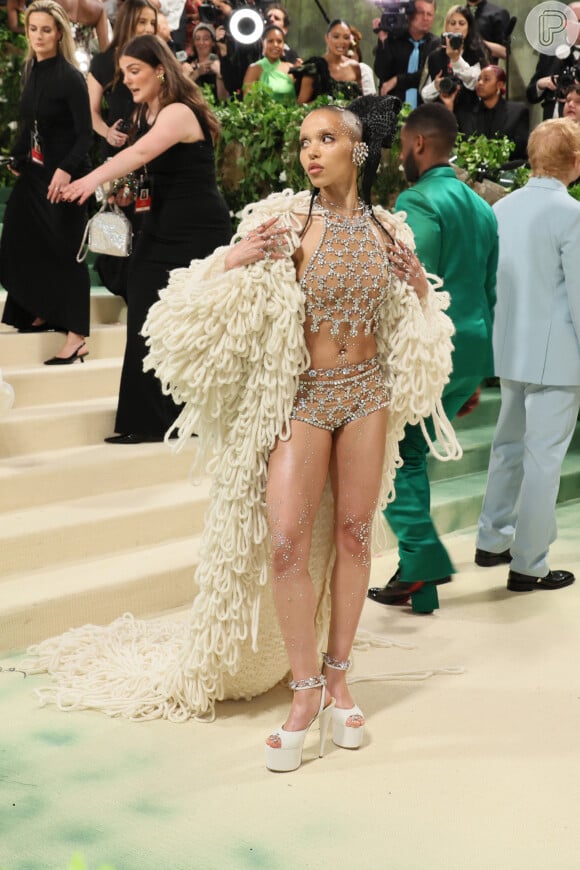 MET Gala 2024: FKA Twigs usou e abusou da ousadia e segunda pele com um look todo cravejado. Destaque para o casacão que fez uma grande cauda no clão