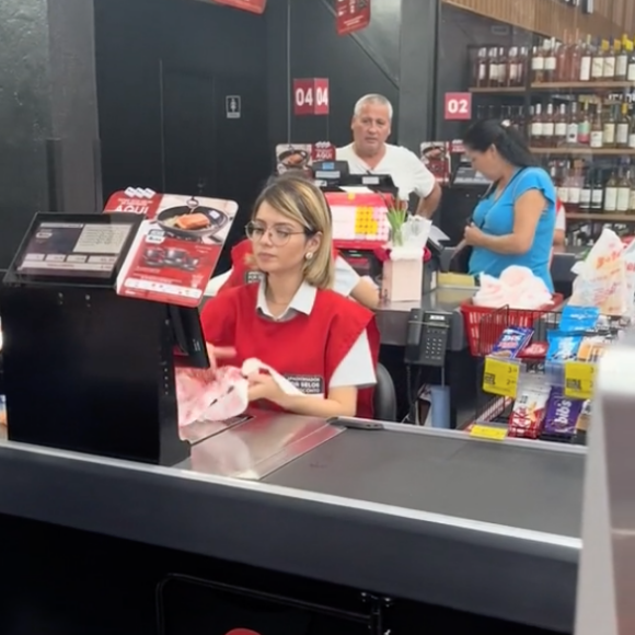 Uma jovem viralizou nas redes sociais após ser filmada trabalhando no caixa de um supermercado