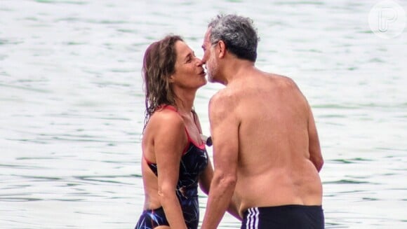 Andréa Beltrão, aos 60 anos, curte praia do Rio de Janeiro com maiô vazado e beija muito o marido