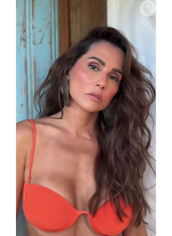 Usando um biquíni laranja e com muito carão, Deborah Secco valorizou sua beleza e sensualidade únicos no vídeo