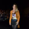 Carolinie Figuereido prestigiou o desfile da Ellus 2nd floor, no primeiro dia de Fashion Rio. A atriz usou uma jaqueta laranja para colorir o look