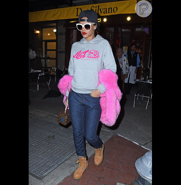 Para dar um up na combinação de jeans, yellow boot e moletom, Rihanna ousou na escolha de um boá rosa pink
