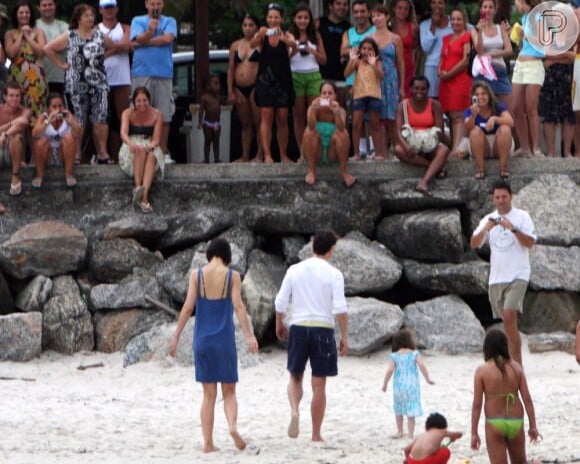 Tom Cruise, Katie Holmes e Suri são flagrados na praia da Urca, no Rio de Janeiro, enquanto são observados por populares, em fevereiro de 2009