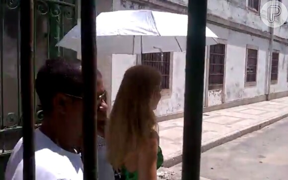 Uma funcionária da TV Globo esperou Angélica para acompanhá-la, segurando seu guarda-sol