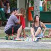 Thiago Lacerda e Vanessa Lóes passaram boa parte do tempo brincando com os filhos sentados em uma talha no gramado da pracinha