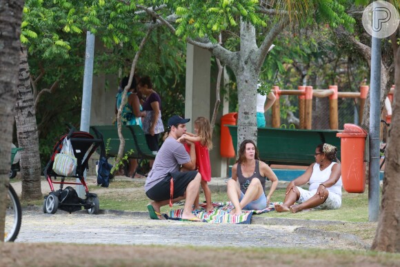 Thiago Lacerda e Vanessa Lóes passaram boa parte do tempo brincando com os filhos sentados em uma talha no gramado da pracinha