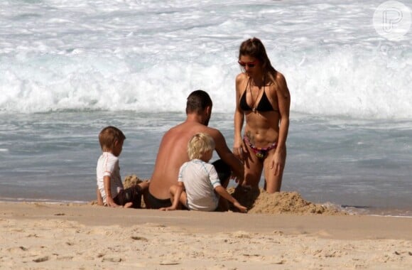 Fernanda Lima exibe seu corpão na praia com o marido, Rodrigo Hilbert, e com os filhos, João e Francisco, de 5 anos