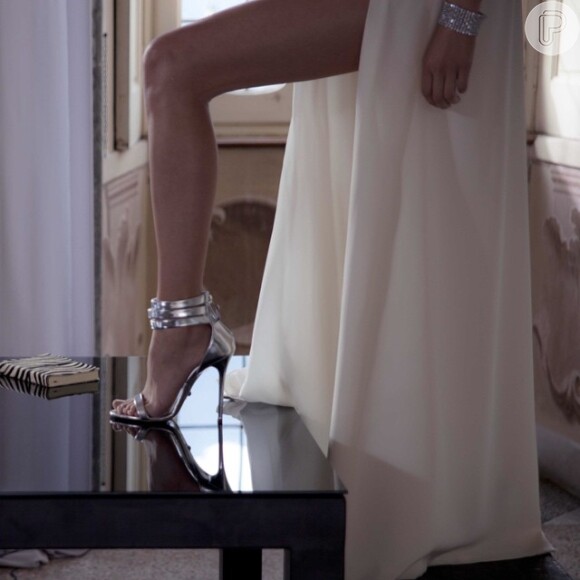 No comercial gravado na Itália, Ana Beatriz Barros surge vestida para matar em um vestido branco com uma fenda generosa nas pernas