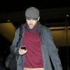 Ryan Reynolds checa o celular em aeroporto