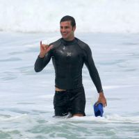 Cauã Reymond, com novo visual, corre em praia do RJ e se diverte pegando jacaré