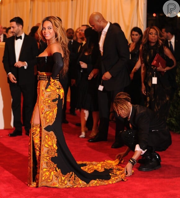 Beyoncé recebe ajuda para deixar a cauda longa de seu vestido perfeita para os fotógrafos