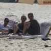 Bradley Cooper relaxa em espreguiçadeira na praia de Ipanema