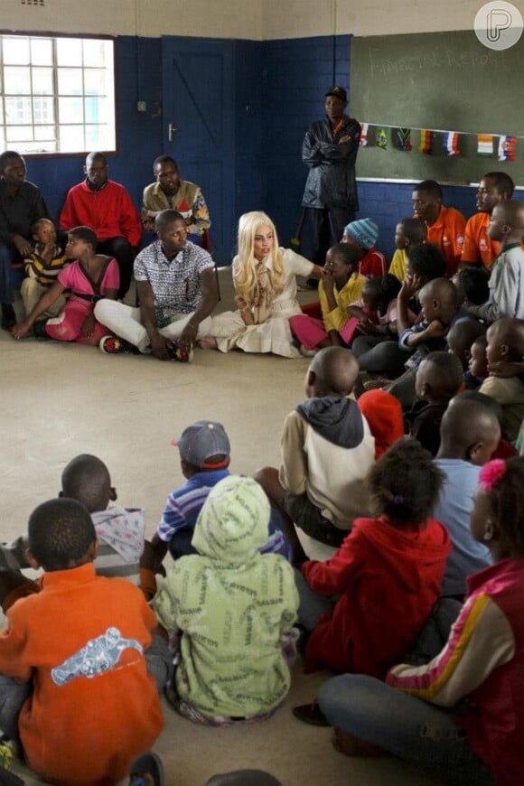 Lady Gaga senta em uma roda com as crianças do projeto para divulgar a mensagem de compaixão que tanto apregoa