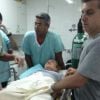 Foto mostra Angélica sendo atendida no hospital Santa Casa de Campo Grande, sob o olhar de Luciano Huck, após avião em que a família viajava ter que fazer um pouso forçado