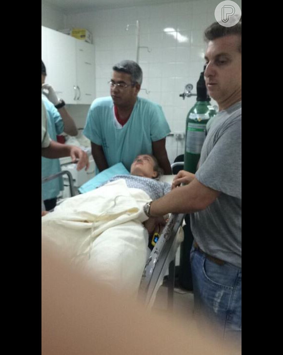Foto mostra Angélica sendo atendida no hospital Santa Casa de Campo Grande, sob o olhar de Luciano Huck, após avião em que a família viajava ter que fazer um pouso forçado