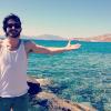 Fiuk posa em frente a praia da ilha de Mykonos, na Grécia