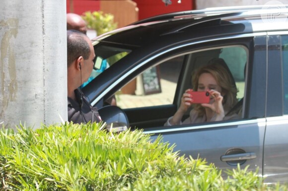 De dentro do carro, Mariana Ximenes tira foto do local com seu celular