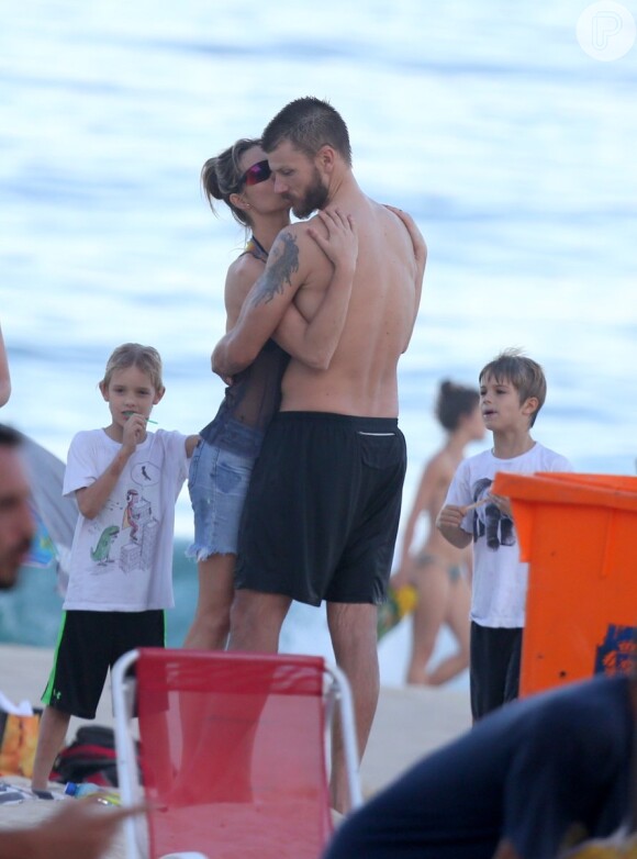 Fernanda Lima beija o marido, Rodrigo Hilbert, ao lado dos filhos gêmeos, João e Franciso, na praia do Leblon, Zona Sul do Rio de Janeiro, em 19 de julho de 2015