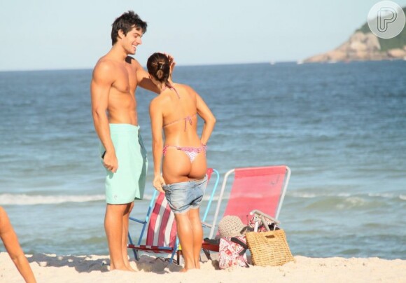 Maurício faz carinhono rosto da namorada enquanto ela se veste para deixar a praia