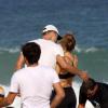 Fernanda Lima e Rodrigo Hilbert se abraçam em um dia de sol na praia do Leblon