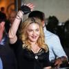 Madonna acenou para os fãs e a imprensa na saída da inauguração da academia que ela assina