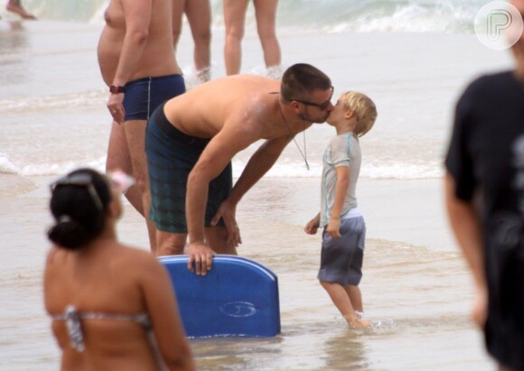 Rodrigo Hilbert mostrou o seu lado 'paizão' em praia carioca. Na foto, o ator beija o filho, João